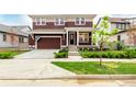 Charming two-story home with a covered porch, landscaped yard, and a driveway leading to the garage at 1826 Hickory Ave, Erie, CO 80516