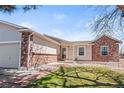 Inviting front exterior showcasing the home's brick facade, well-maintained lawn, and welcoming entrance at 8900 Iris Ct, Broomfield, CO 80021