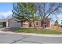 Quaint single-Gathering home featuring a manicured front lawn, mature trees, and an attached two-car garage at 8900 Iris Ct, Broomfield, CO 80021