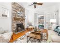 Cozy living room featuring a stone fireplace, hardwood floors, and access to the sunroom at 1723 E 16Th Ave, Denver, CO 80218