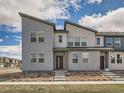 Modern townhouse exterior features a gray facade, red door, and desert-style landscaping at 6492 N Ceylon St, Denver, CO 80249