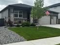 Well-maintained single-story home with a lush lawn, covered porch, and a two-car garage at 13432 Broad Wing Dr, Parker, CO 80134