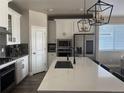 Modern kitchen with stainless steel appliances, a center island, and stylish pendant lighting at 13432 Broad Wing Dr, Parker, CO 80134