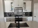 Beautiful kitchen featuring stainless steel appliances, white cabinetry, and a backsplash at 13432 Broad Wing Dr, Parker, CO 80134