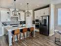 Modern kitchen featuring white cabinets, stainless steel appliances, and a stylish center island with seating at 13432 Broad Wing Dr, Parker, CO 80134