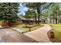 Beautiful home with manicured landscaping, brick accents, and mature trees at 19070 White Fawn Dr, Monument, CO 80132