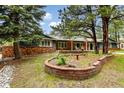 Lovely home with blue siding, brick accents, a quaint garden, and mature trees at 19070 White Fawn Dr, Monument, CO 80132