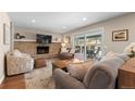 Cozy living room with fireplace, plush seating, and access to outdoor patio at 10703 W Turtle Mtn, Littleton, CO 80127