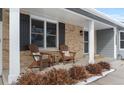 Inviting covered front porch with brick accents and seating area at 10703 W Turtle Mtn, Littleton, CO 80127