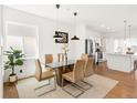 Bright dining room features modern light fixture, glass table, and stylish decor at 11041 Richfield Cir, Commerce City, CO 80022