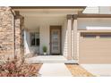 A close-up shot of the front porch with stone accents and a modern front door with five glass inserts at 11041 Richfield Cir, Commerce City, CO 80022