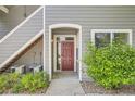 Charming condo entrance with a red door, sidewalk, and verdant landscaping at 8500 E Jefferson # 3C, Denver, CO 80237