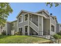 Well-maintained two-story condo with lush lawn, featuring a staircase entrance and gray exterior at 8500 E Jefferson # 3C, Denver, CO 80237
