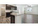Open concept kitchen with island and stainless steel appliances at 26774 E Archer Ave, Aurora, CO 80018