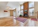 Bright living room features a brick fireplace, wood floors, and large windows at 7696 S Monaco E Cir, Centennial, CO 80112