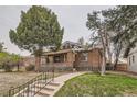 Attractive brick home featuring a covered porch and lush front yard at 2866 Bellaire St, Denver, CO 80207