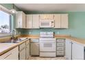 Bright kitchen features white appliances, tile flooring, wood countertops, and natural light, offering a functional cooking space at 8635 Clay St # 417, Westminster, CO 80031
