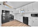 Bright kitchen with stainless steel appliances, lots of white cabinets, and laminate floors at 1255 Nelson St, Lakewood, CO 80215