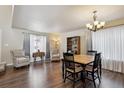 Bright living room with hardwood floors, large windows, a cozy arm chair and natural light at 9457 Morning Glory Ln, Highlands Ranch, CO 80130