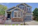 Charming home with stone accents, a cozy front porch, and well-maintained landscaping at 9996 Sedalia St, Commerce City, CO 80022