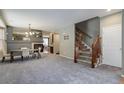 Inviting living room featuring a fireplace, dining area, and staircase, perfect for Gathering gatherings at 9996 Sedalia St, Commerce City, CO 80022