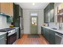 Modern kitchen with dark green cabinets, stainless steel appliances, and wood flooring at 2931 N Josephine St, Denver, CO 80205