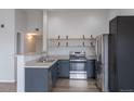 Modern kitchen with stainless steel appliances, dark cabinets, and wooden shelving at 10035 E Carolina Pl # 201, Aurora, CO 80247