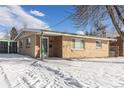 Brick ranch home with snowy yard and mature trees at 7674 Stuart St, Westminster, CO 80030