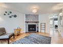 Cozy living room features a stone fireplace, hardwood floors, and unique wall decor at 8136 Washington St # 141, Denver, CO 80229