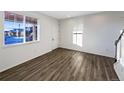 Spacious living room featuring hardwood floors, a window for ample light, and a white door at 3520 Little Bell Dr, Frederick, CO 80516