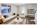 Bright living room is virtually staged with modern furniture, natural light, and hardwood floors at 3520 Little Bell Dr, Frederick, CO 80516