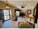 Elegant living room with vaulted ceilings, tile floors, piano, and a view at 1063 Clarke Ct, Castle Rock, CO 80109