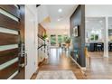 Bright foyer with hardwood floors, a modern staircase, and a view into the dining and living areas at 9678 E Powers Dr, Greenwood Village, CO 80111