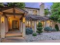 Inviting front entrance with a modern door, stone pillars, stylish lighting, and meticulously arranged rock landscaping at 9678 E Powers Dr, Greenwood Village, CO 80111