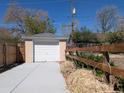 View of detached one car garage with white door and concrete driveway at 1171 Quebec St, Denver, CO 80220