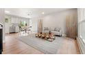Open-concept living room with hardwood floors, a comfortable sofa, and a dining area with stainless appliances at 2108 S Idalia St, Aurora, CO 80013