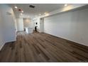 Open-concept living room featuring wood-look floors, recessed lighting, and an adjacent kitchen at 6638 N Nepal Ct, Aurora, CO 80019