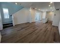 Bright living room with wood-look floors, recessed lighting, and a staircase to the second floor at 6638 N Nepal Ct, Aurora, CO 80019