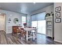 Dining area featuring stylish wood-look floors, a modern table set, and great natural light at 952 Morning Glory Rd, Brighton, CO 80640