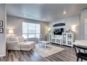 Sunlit living room boasting sleek flooring, a comfortable couch, and modern decor at 952 Morning Glory Rd, Brighton, CO 80640