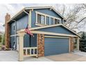Two-story home featuring blue siding, brick accents, a large garage, and an American flag at 4620 W 108Th Pl, Westminster, CO 80031