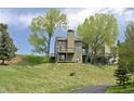 Backyard view of the property, featuring multi-level decks and grassy hillside at 23846 Genesee Village Rd, Golden, CO 80401