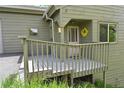 Inviting front porch featuring a cheerful yellow wreath and a gray painted deck at 23846 Genesee Village Rd, Golden, CO 80401