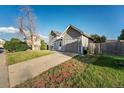 A gray home with an attached garage features a driveway and fenced-in yard at 16980 E Stanford Ave, Aurora, CO 80015