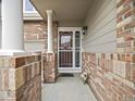 Inviting front entrance featuring brick accents and a secure storm door at 6432 S Robb Ct, Littleton, CO 80127
