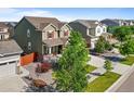 A high angle view shows a traditional home with a well manicured lawn and mature trees in a vibrant community at 14912 Vienna Cir, Parker, CO 80134