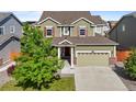 Charming two-story home featuring a two-car garage and a well-manicured front lawn with a mature tree at 14912 Vienna Cir, Parker, CO 80134