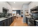 Stylish kitchen with herringbone backsplash, dark hardware, and wood floors at 3109 N Williams St, Denver, CO 80205