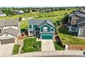 Aerial view of a two-story home with a manicured lawn, set against a scenic greenbelt backdrop at 3543 Foxridge Trl, Highlands Ranch, CO 80126