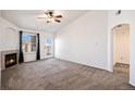 Spacious living room with neutral carpet, fireplace, and walkout to the balcony at 5756 N Genoa Way # 12-305, Aurora, CO 80019